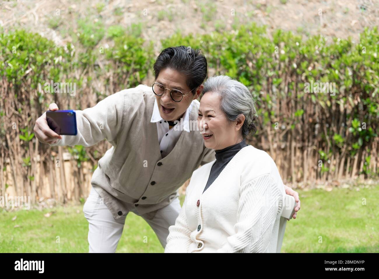 Ein asiatisches älteres Paar benutzt ein Mobiltelefon, um Selfies zu machen Stockfoto