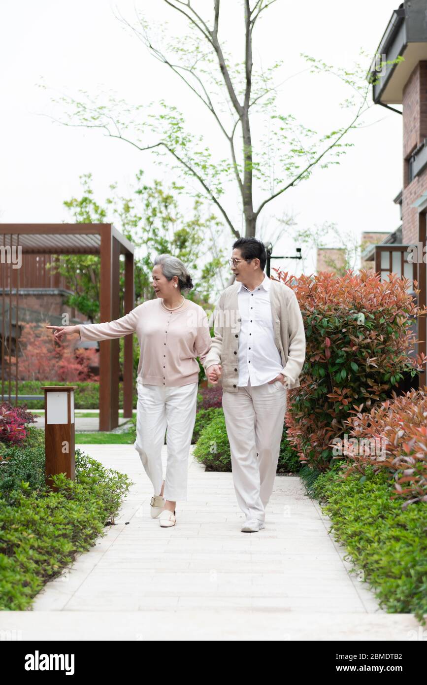 Ein asiatisches älteres Paar, das in der Gemeinde spazierengeht Stockfoto