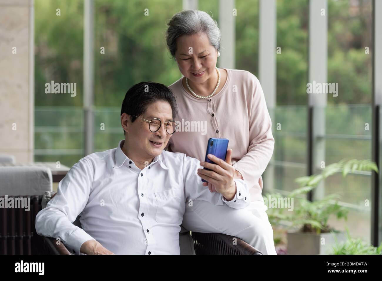 Ein asiatisches älteres Paar auf einem Outdoor-Stuhl Stockfoto