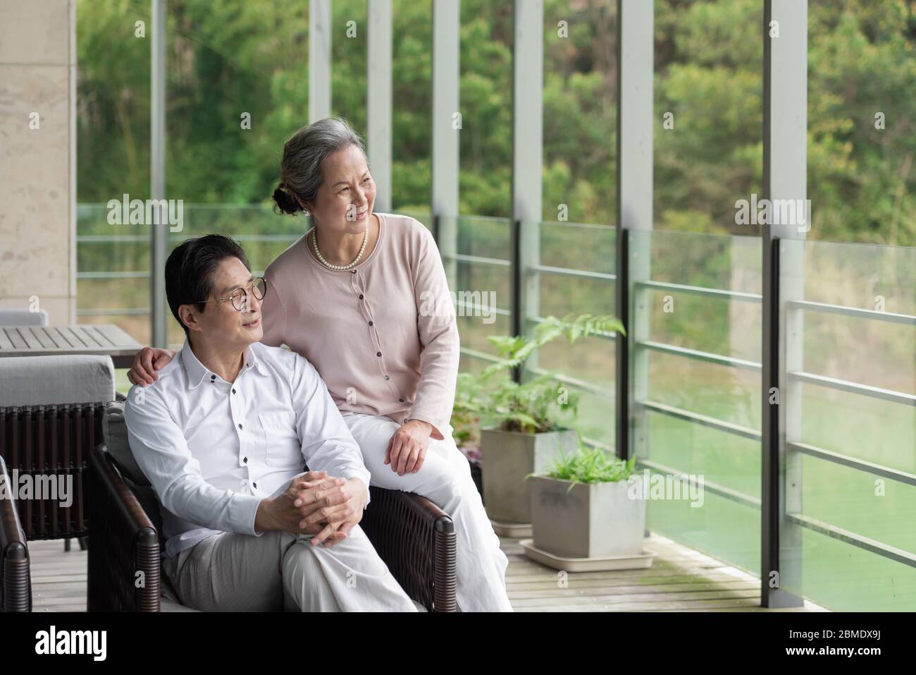 Ein asiatisches älteres Paar auf einem Outdoor-Stuhl Stockfoto