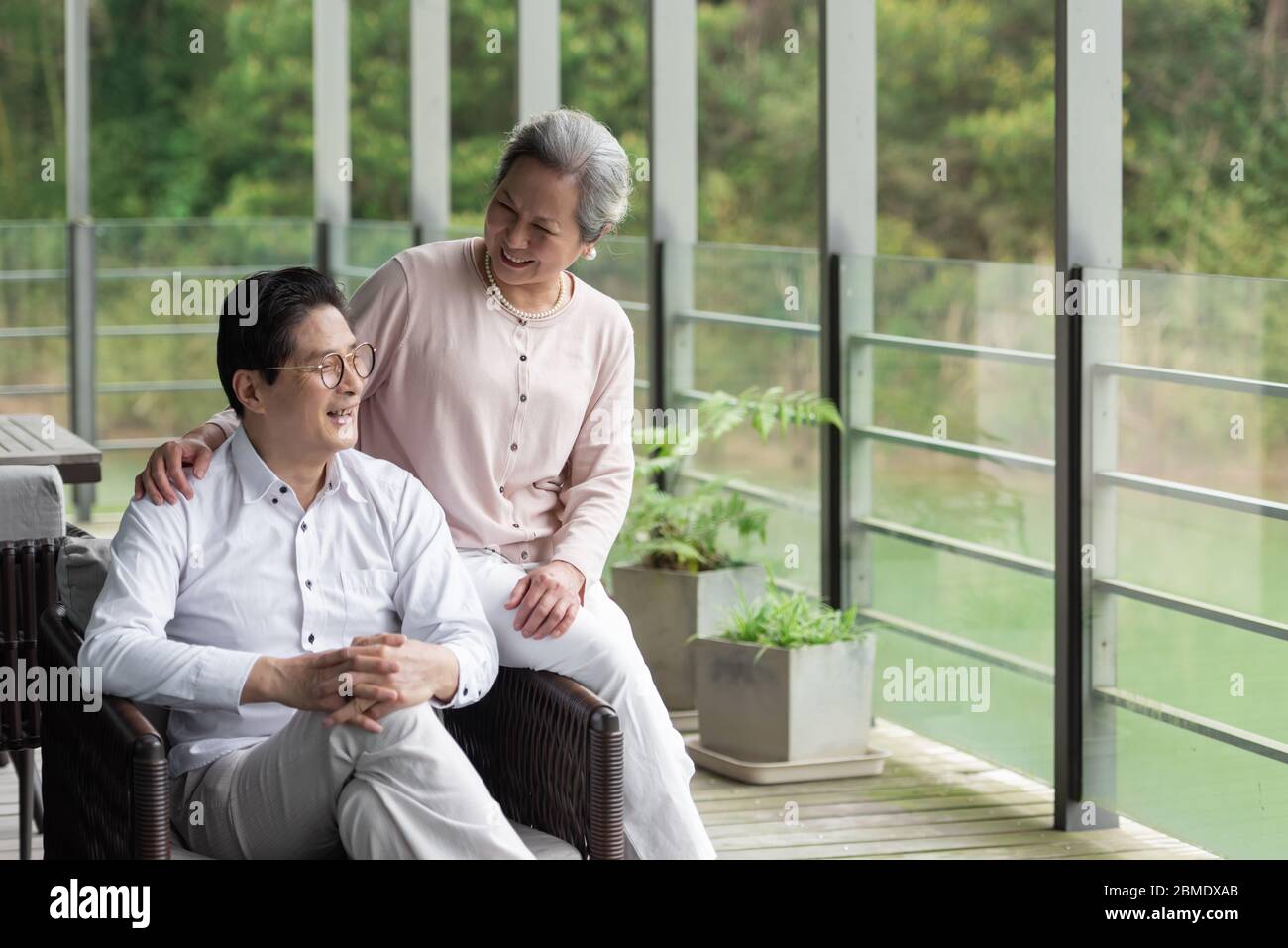 Ein asiatisches älteres Paar auf einem Outdoor-Stuhl Stockfoto