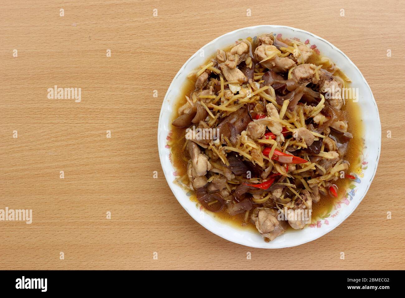 Draufsicht. Hähnchenbrust mit Ingwer aus Pilzen, Knoblauch, frischen Paprika auf einem Teller und auf einem Holzhintergrund gelegt. Stockfoto