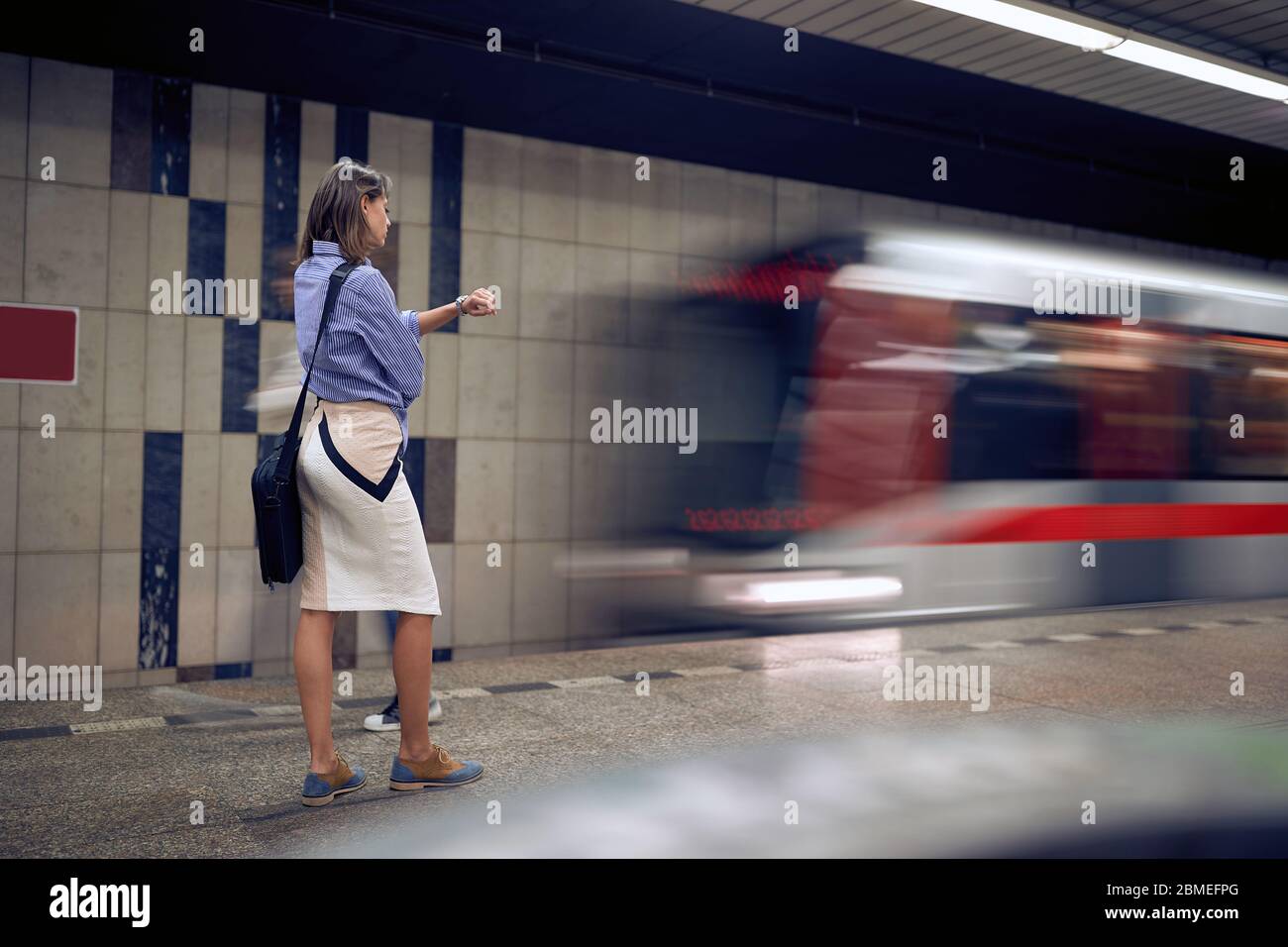 Geschäftsfrau wartet auf U-Bahn in U-Bahn.Junge Frau wartet auf einen Zug in der U-Bahn. Stockfoto