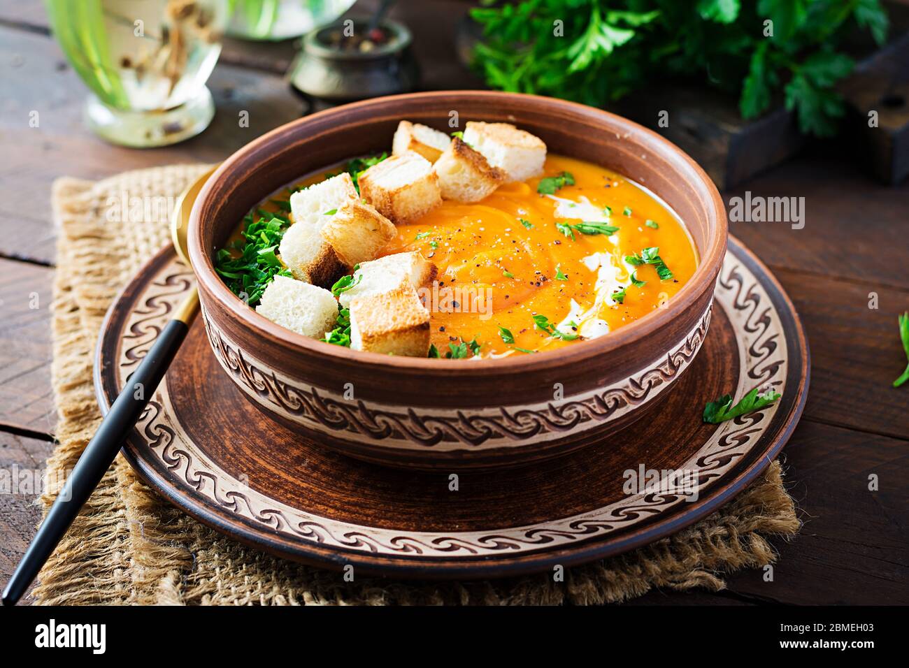 Kürbissuppe in einer Schüssel mit Croutons und Petersilie serviert. Vegane Diät Suppe. Vegetarisches Essen. Stockfoto