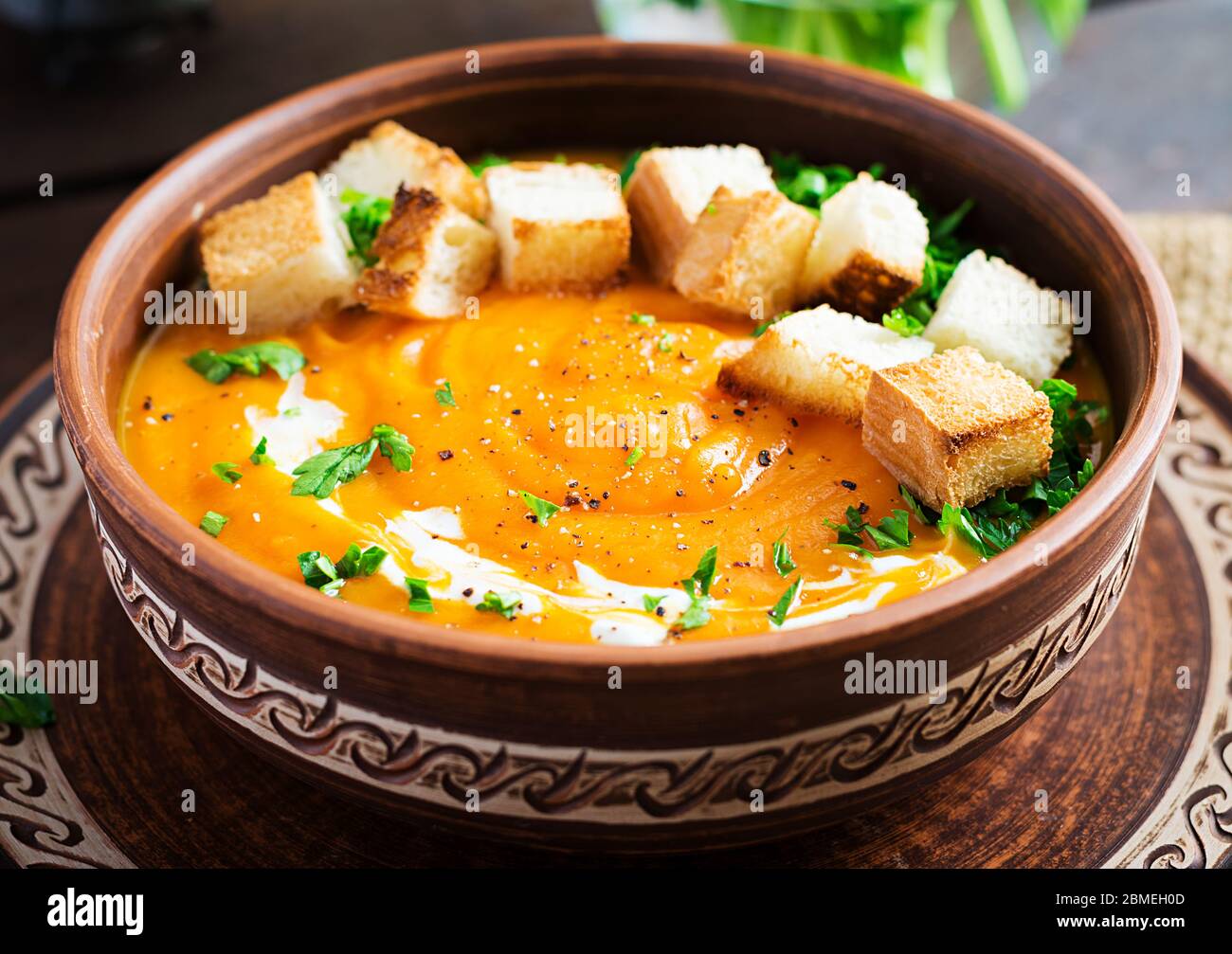 Kürbissuppe in einer Schüssel mit Croutons und Petersilie serviert. Vegane Diät Suppe. Vegetarisches Essen. Stockfoto