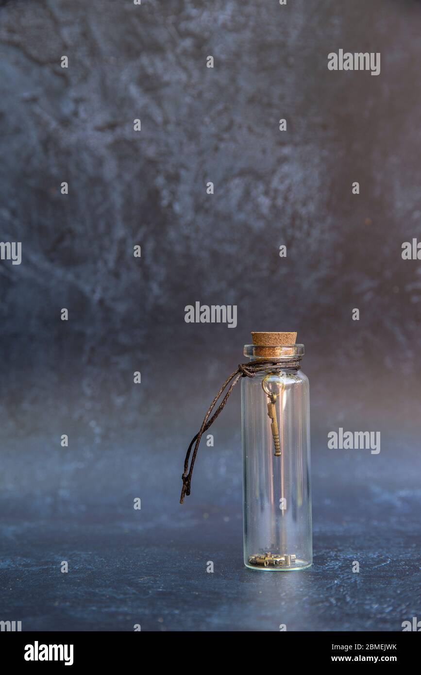 Romantische alte vintage Glas Wunsch Flasche mit Glück Charme in der Flasche mit Kork Topper und antiken Effekt Hintergrund Stockfoto