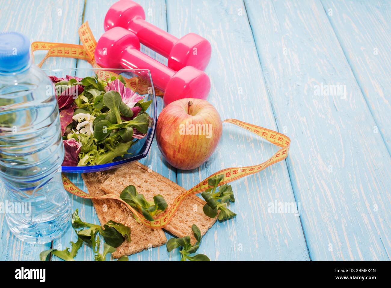 Frisches organisches Gemüse mit Hanteln auf einem Holzkontertop, Kopierraum, Ernährung und das Konzept des gesunden Essens. Stockfoto