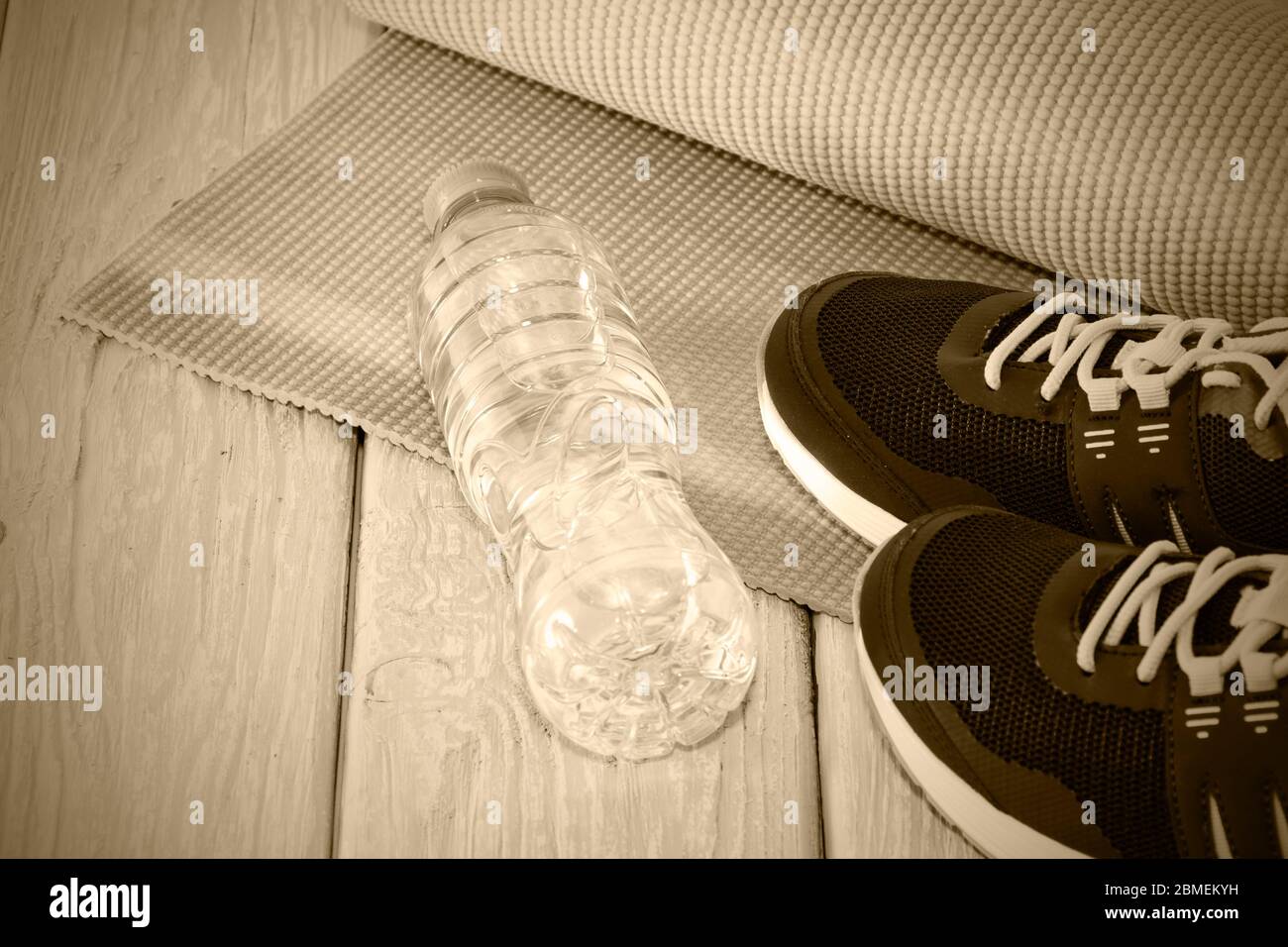 Yogamatte, Sportschuhe, eine Flasche Wasser, das Konzept eines gesunden Lebensstils, gesunde Ernährung, Sport und Ernährung, Toning grau Stockfoto