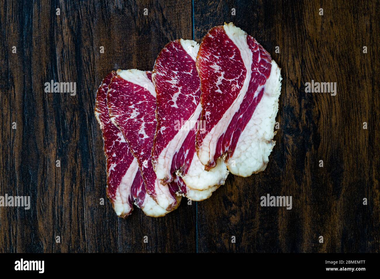 Roh Geräucherte Trockene Gereifte Kalbsrippenscheiben. In Scheiben geschnitten und geschnitten Schinken / Salami. Bereit zum Essen. Stockfoto