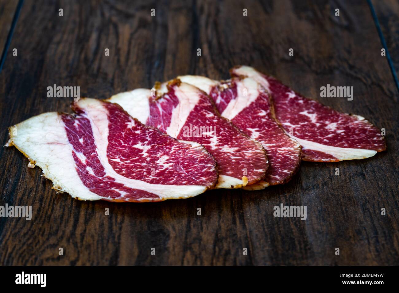 Roh Geräucherte Trockene Gereifte Kalbsrippenscheiben. In Scheiben geschnitten und geschnitten Schinken / Salami. Bereit zum Essen. Stockfoto