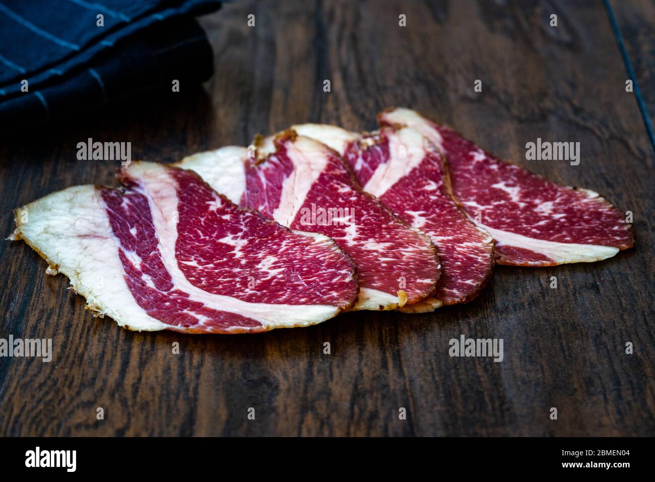 Roh Geräucherte Trockene Gereifte Kalbsrippenscheiben. In Scheiben geschnitten und geschnitten Schinken / Salami. Bereit zum Essen. Stockfoto