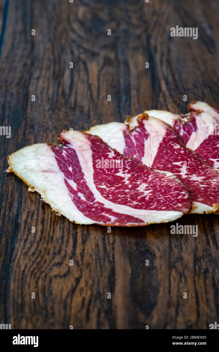 Roh Geräucherte Trockene Gereifte Kalbsrippenscheiben. In Scheiben geschnitten und geschnitten Schinken / Salami. Bereit zum Essen. Stockfoto