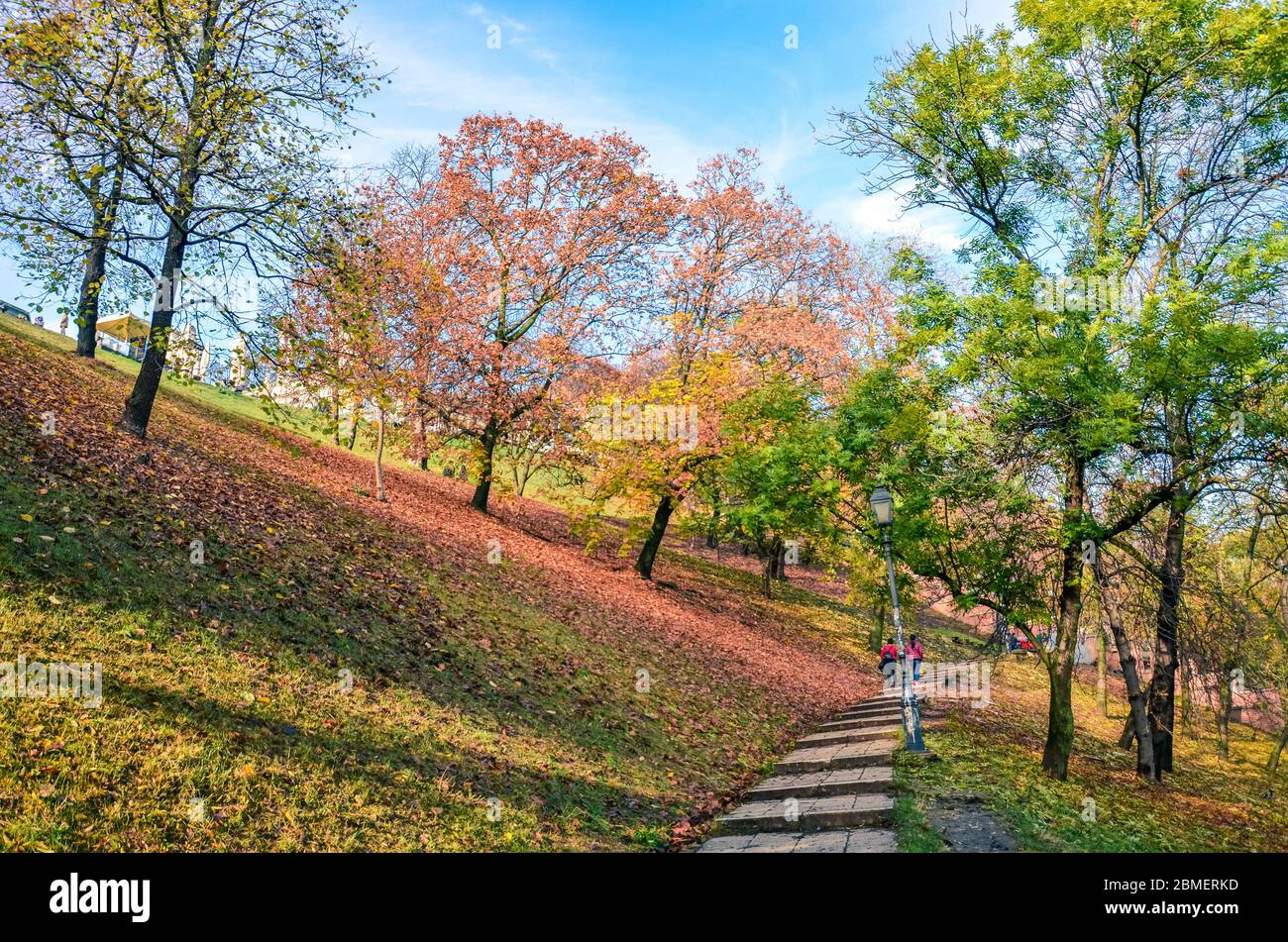 Herbstbäume entlang der Treppe im Park, der zum Budaer Schloss in Budapest, Ungarn führt. Herbstzweige und Laub. Herbstbäume in orange und rot. Jahreszeiten des Jahres. Horizontales Foto. Stockfoto