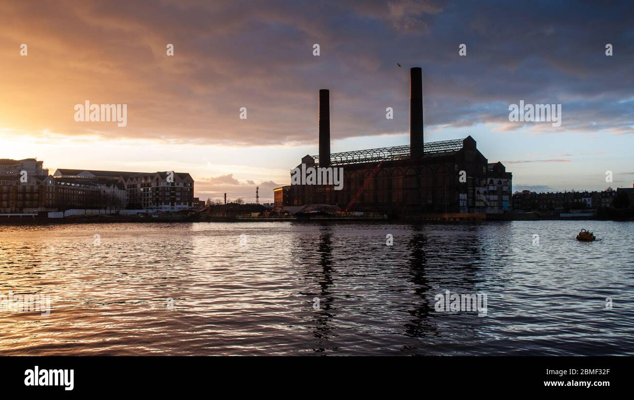 London, England, UK - 15. Februar 2013: Die Sonne geht über dem verödenen Lots Road Power Station und den neu erbauten Wohngebäuden des Chelsea Harbour d Stockfoto