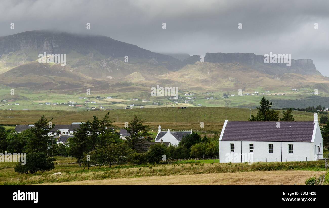 Verstreute Häuser von Staffin sind die Landschaft des Quiraing auf der Isle of Skye. Stockfoto