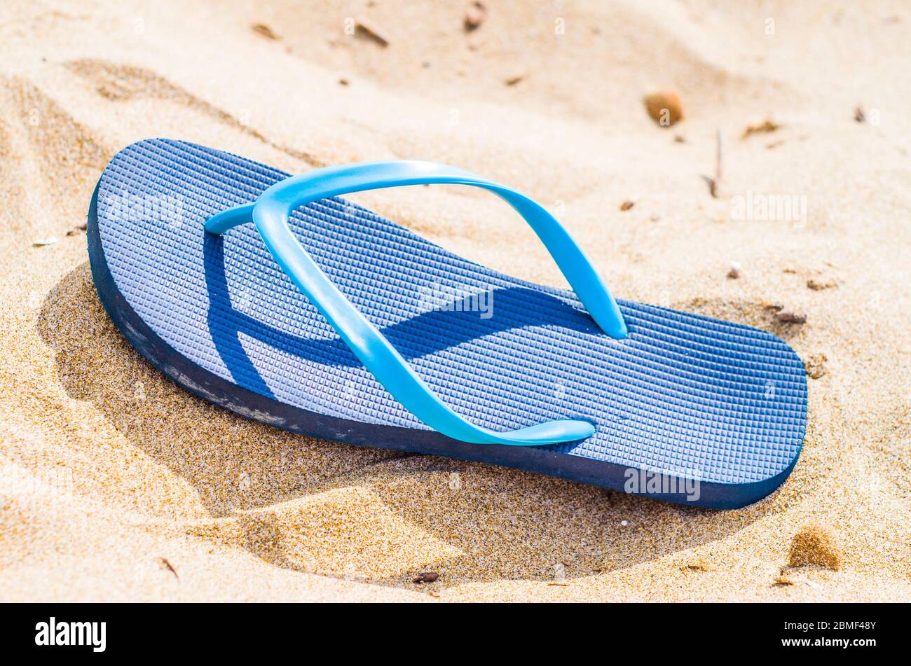 Symbol des Sommers: Flip Flops kühlen Ihren schweißtreibenden Fuß im heißen Sand des heißen Sommers Stockfoto