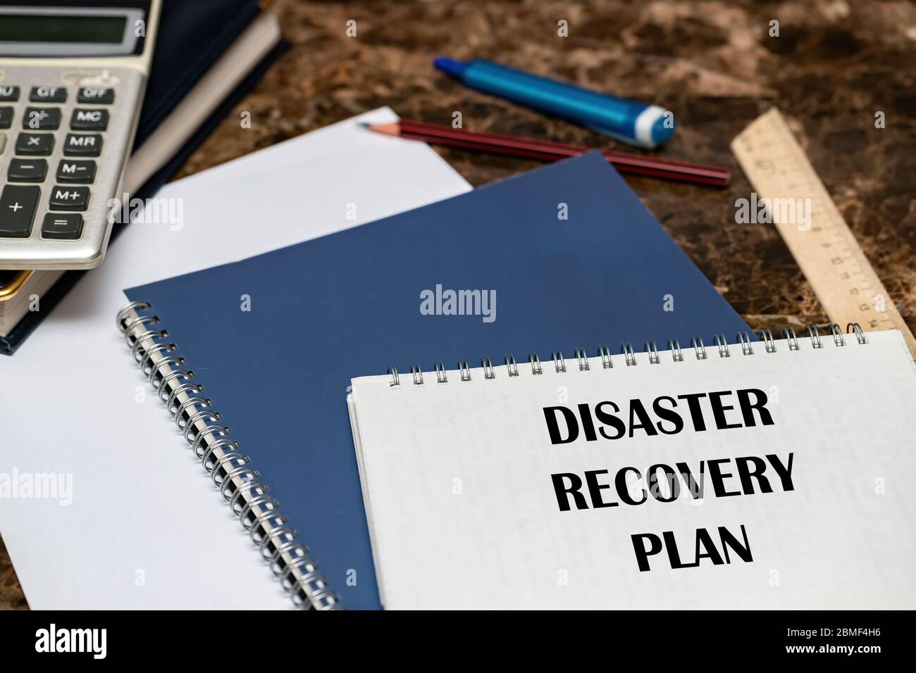 Der Text des Disaster Recovery-Plans ist auf einem weißen Blatt auf dem Büroschreibtisch geschrieben. Stockfoto
