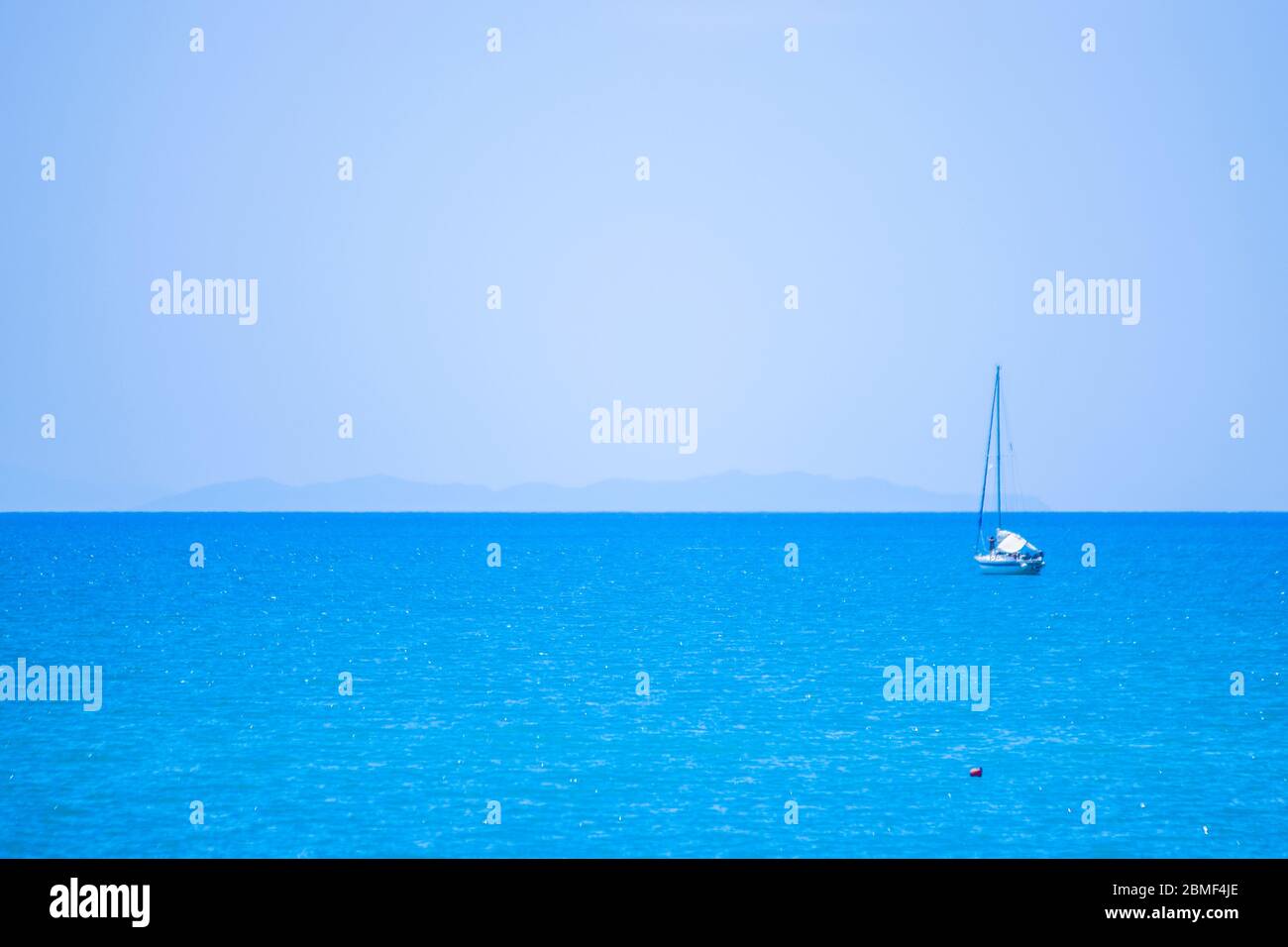 navigator auf dem Boot im blauen Meer und unter dem blauen Himmel Flecken Insel auf der Spitze Stockfoto