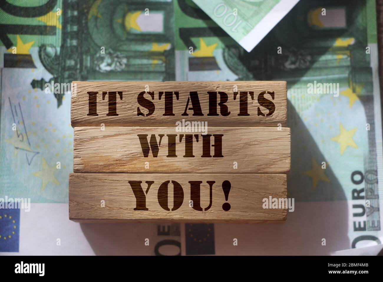 Es beginnt mit Ihnen, Satz auf vwooden Blöcke geschrieben stehen auf 100 Euro-Scheinen. Professionelle Fähigkeiten und Leistungen Konzept. Persönliche Speicherung und Stockfoto