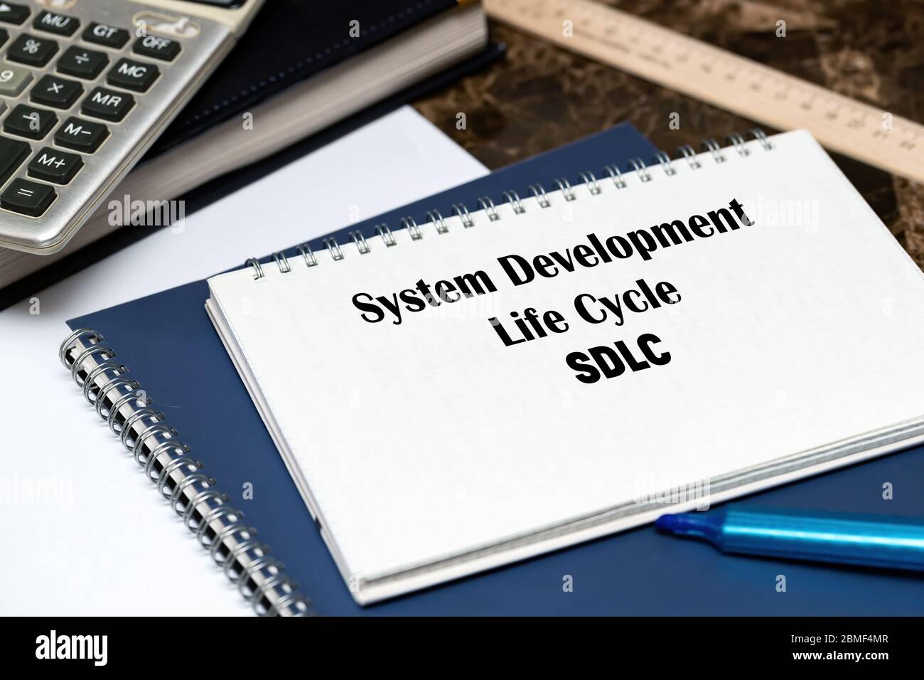 SDLC - System Development Life Cycle, Abkürzung für Business Concept. Der Text ist auf einem weißen Blatt geschrieben, das auf dem Büromarmortisch liegt. Stockfoto