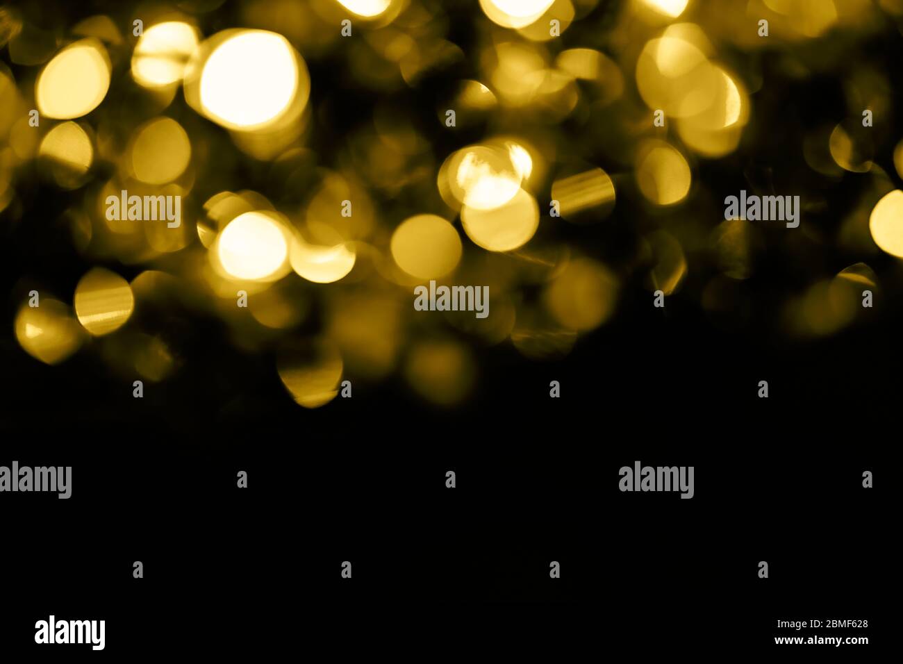 Trendy Gelbgold Kreise Bokeh festliche Glitzer dunklen Hintergrund mit Kopie Raum. Weihnachtslichter Bokeh Overlay-Muster. Modernes, abstraktes Luxus-Design Stockfoto