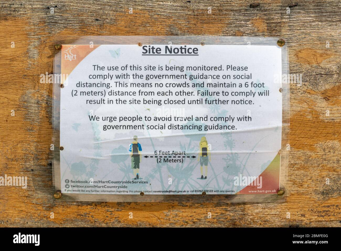 Hinweis über soziale Distanzierung während der 2020 Coronavirus Covid-19 Pandemie auf einer Tafel in einem Landschaftspark, lokaler Grünfläche, Großbritannien Stockfoto