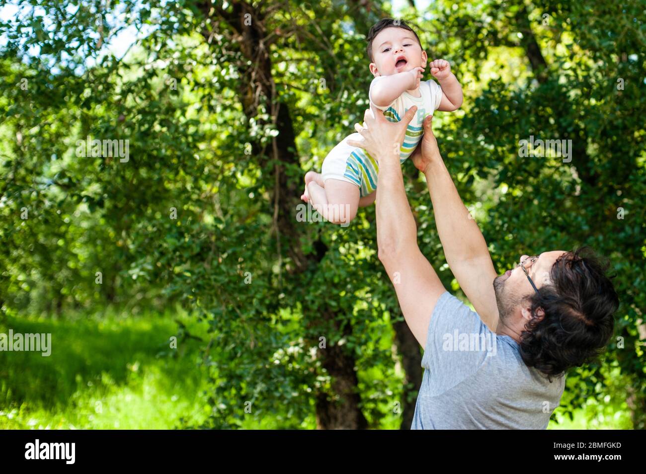 Junger Vater spielt mit seinem Sohn im Freien an einem sonnigen Tag. Vater´s Tageskonzept. Stockfoto