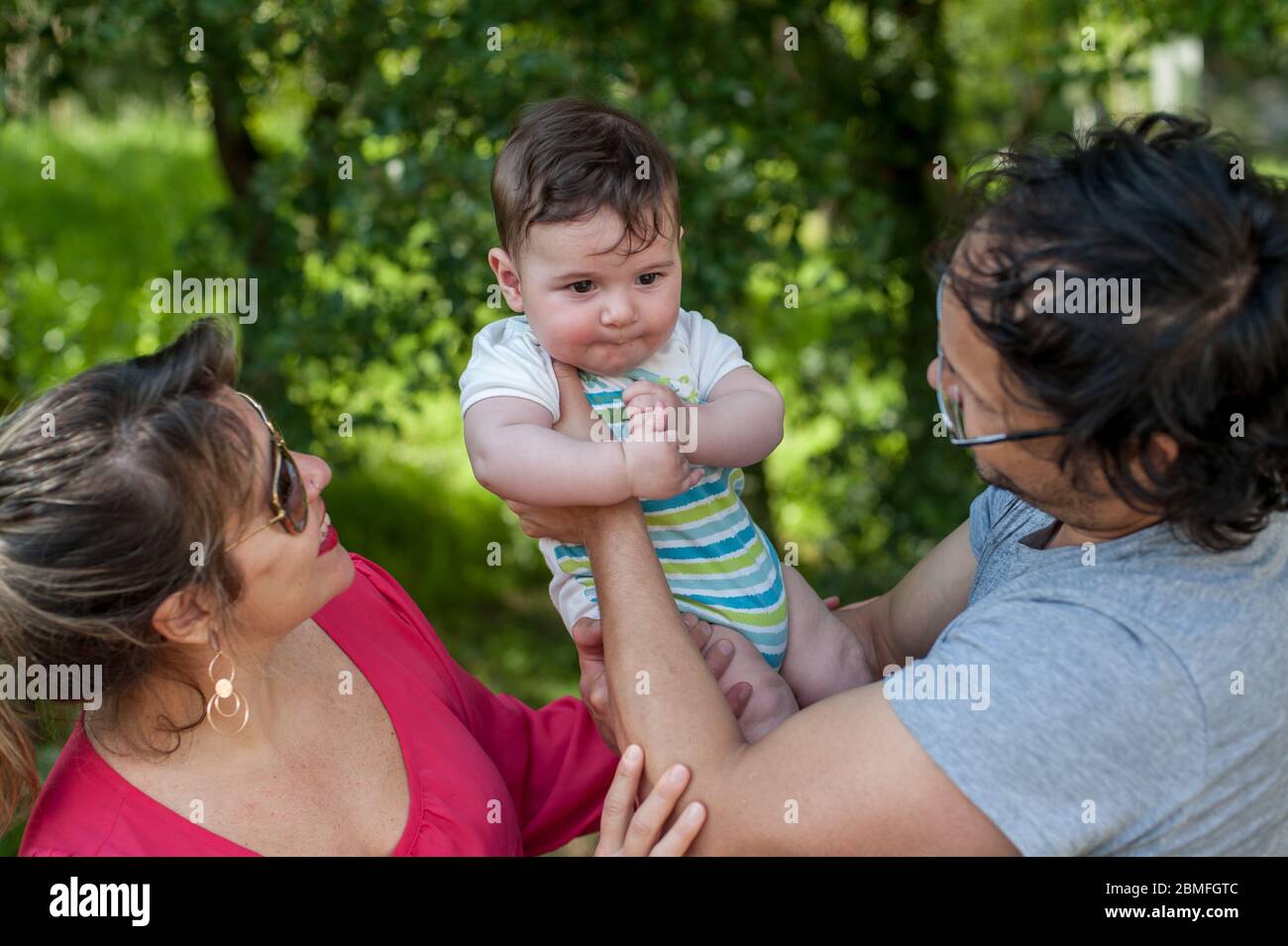 Eltern spielen mit ihrem Baby im Park. Stockfoto