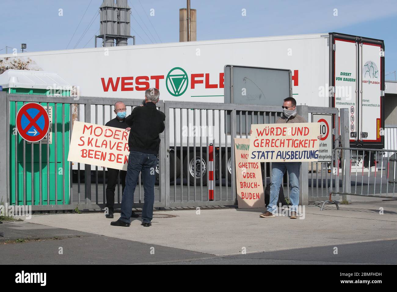 firo: 09.05.2020 General Corona Virus Kreis Coesfeld, Westfleisch, Verlängerung der Corona-Beschränkungen Protest zweier Gegner der modernen Arbeitersklaverei vor der geschlossenen Fabrik in Coesfeld links: Privat Peter Kossen und rechts mit Dominik Blum (rechts) mit Plakaten "Schmach und Gerechtigkeit statt Ausbeutung" vor dem Westfleisch-Fabrikator in Coesfeld protestieren sie gegen unfaire Arbeitsbedingungen in der Fleischindustrie. Seit 2017 ist er Pfarrer der Seliger Niels Stensen Gemeinde in Lengerich. 2018 gründete er einen Verein mit dem Namen "Action Dignity and Justice", um Bul zu helfen Stockfoto