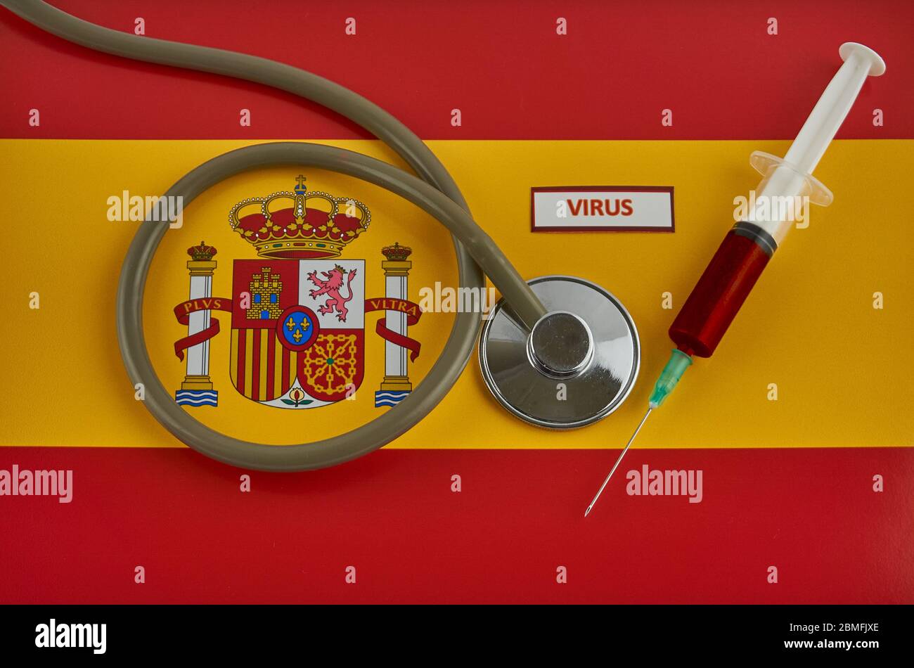 Stethoskop und Spritze auf Spanien Flagge mit Coronavirus-Etikett Stockfoto