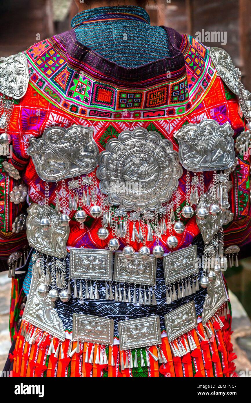 Eine junge Frau zeigt ihr buntes traditionelles Kleid mit allen Dekorationen auf der Rückseite. Sie ist von der Datang kurzen Rock Miao Minderheit Menschen. Kail Stockfoto