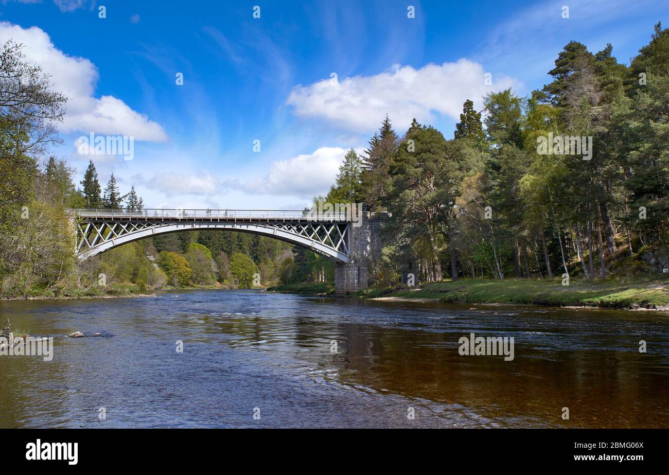 CARRON MORAY SCHOTTLAND DIE STRASSE UND DIE EISENBAHNBRÜCKE ÜBER DEN FLUSS SPEY MIT BÄUMEN IM FRÜHLING Stockfoto