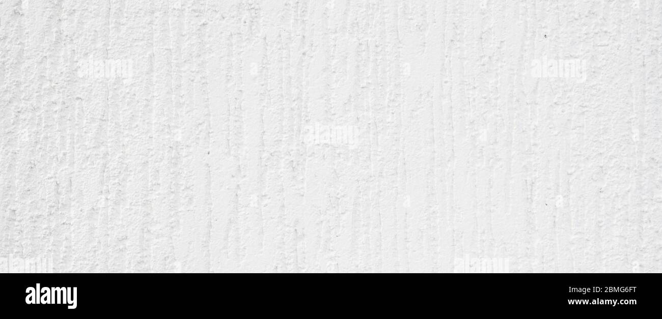 Weiße Wand mit kleinen Kratzern. Detailreiche Wandstruktur Nahaufnahme. Stockfoto