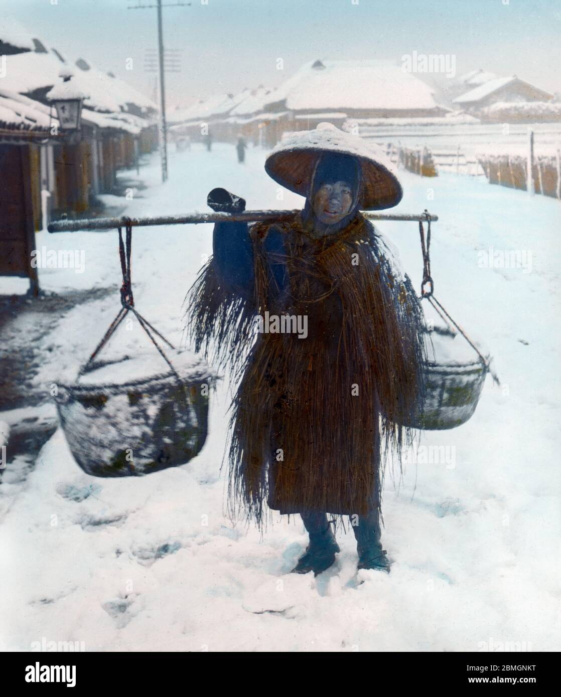 [ 1900er Japan - Japanischer Salzhändler ] - EIN Salzhändler im Schnee, der einen Strohregenmantel (mino) trägt und einen konischen Hut trägt (菅笠, sugegasa). 20. Jahrhundert Vintage Glas Rutsche. Stockfoto