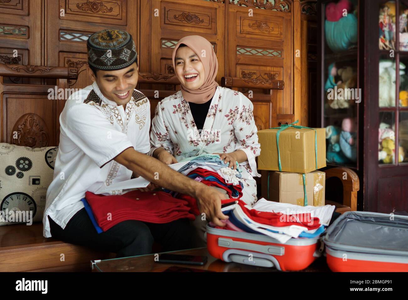 Asiatische muslimische Paar Vorbereitung Verpackung Kleidung für eid mubarak Urlaub Stockfoto