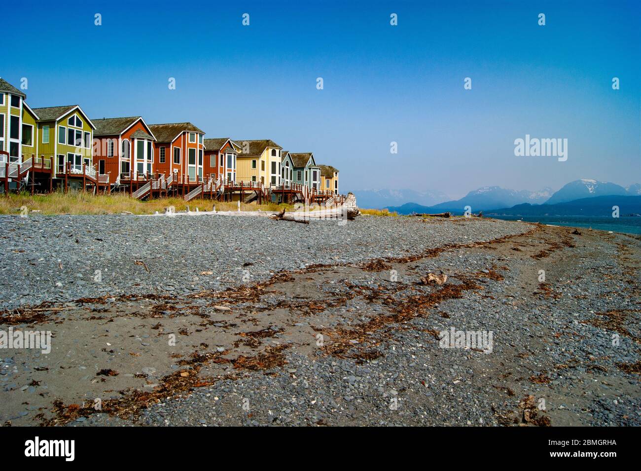 Bunte Häuser am Strand vor einigen Bergen Stockfoto
