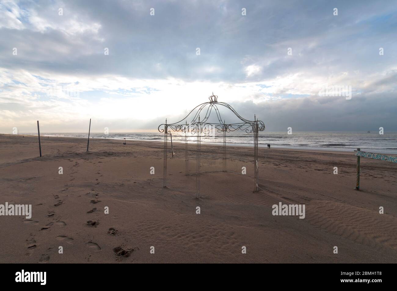Hochzeitskapelle und Lage am Strand in Griechenland. Der Metallrahmen bietet die perfekte Kulisse für Hochzeitsfotos mit Sand und Meer im Hintergrund Stockfoto