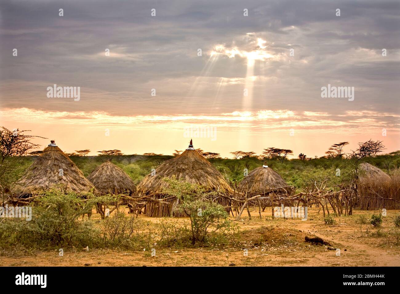 Sonnenstrahlen brechen durch die Wolken über dem Hamer Dorf Kaina. Stockfoto