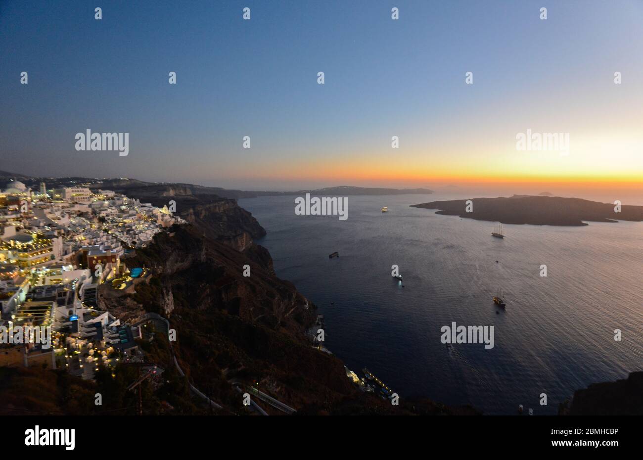 Sonnenuntergang über dem Meer und Dämmerung in den weiß getünchten Häusern in Fira, Stantorini. Griechenland Stockfoto