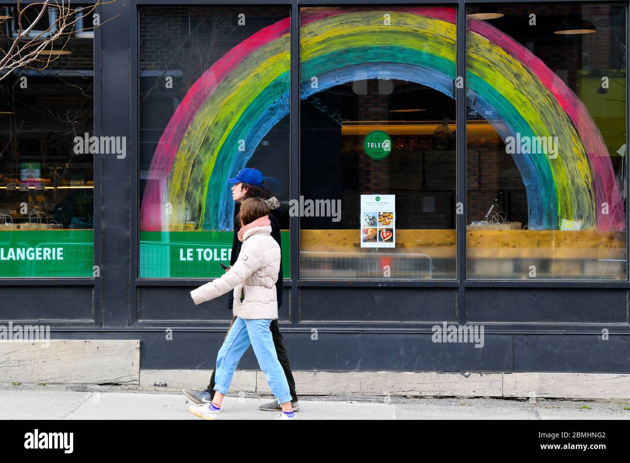 Menschen, die vor einem Geschäft mit einem covid19 Regenbogen der Hoffnung Zeichnung auf sie, Montreal Kanada Stockfoto