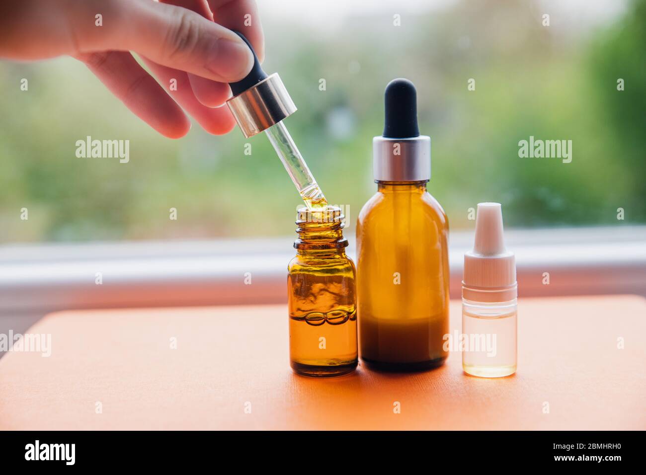 Flasche von natürlichen Öl Serum Beauty-Pflege auf orangefarbenem Hintergrund Stockfoto