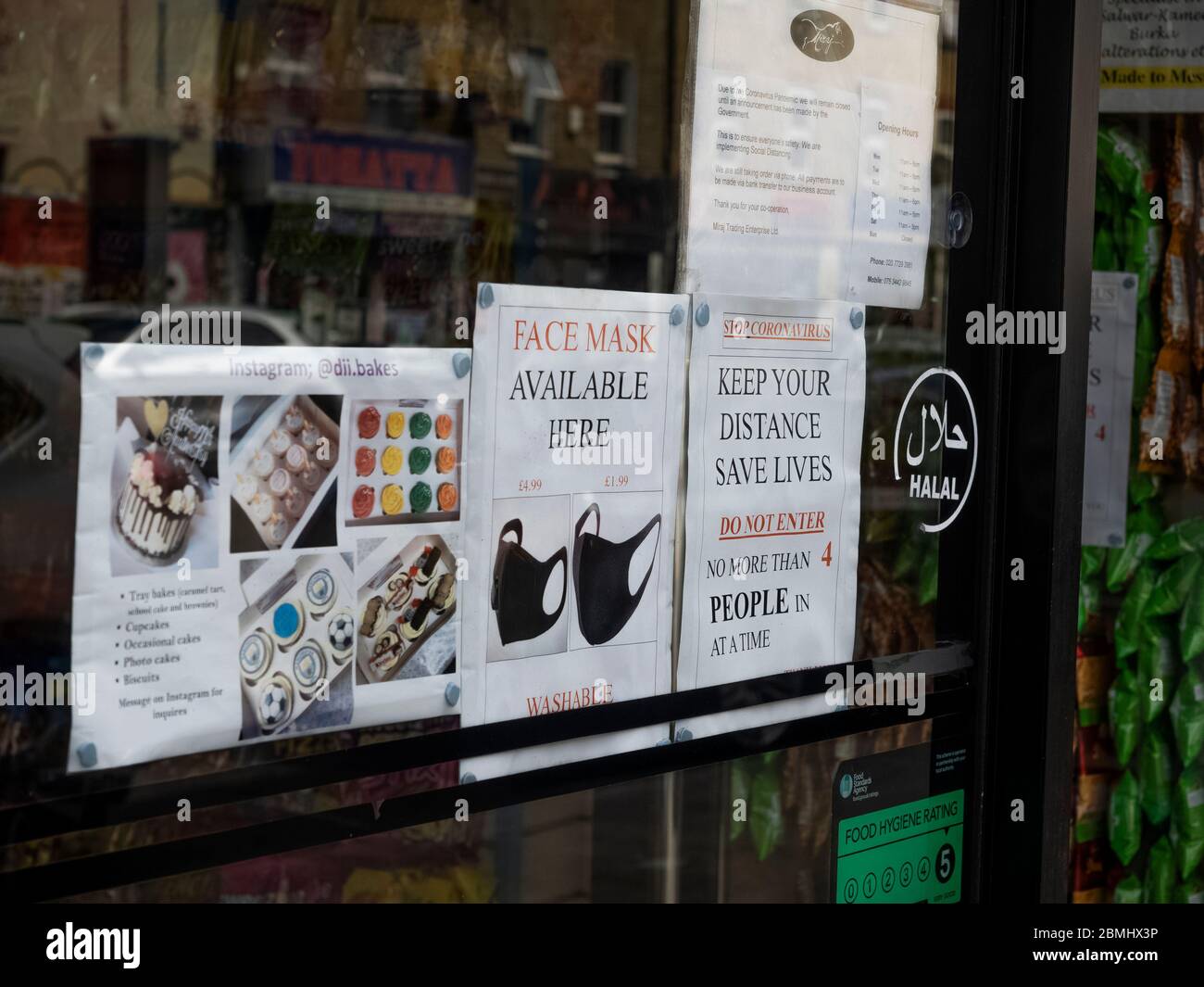 London. GROSSBRITANNIEN. Mai 2020 um 14 Uhr. Nahaufnahme der Business-Haustür in Bethnal Green mit Gesichtsmaske verfügbar Hinweis und Social Distancing Info. Stockfoto