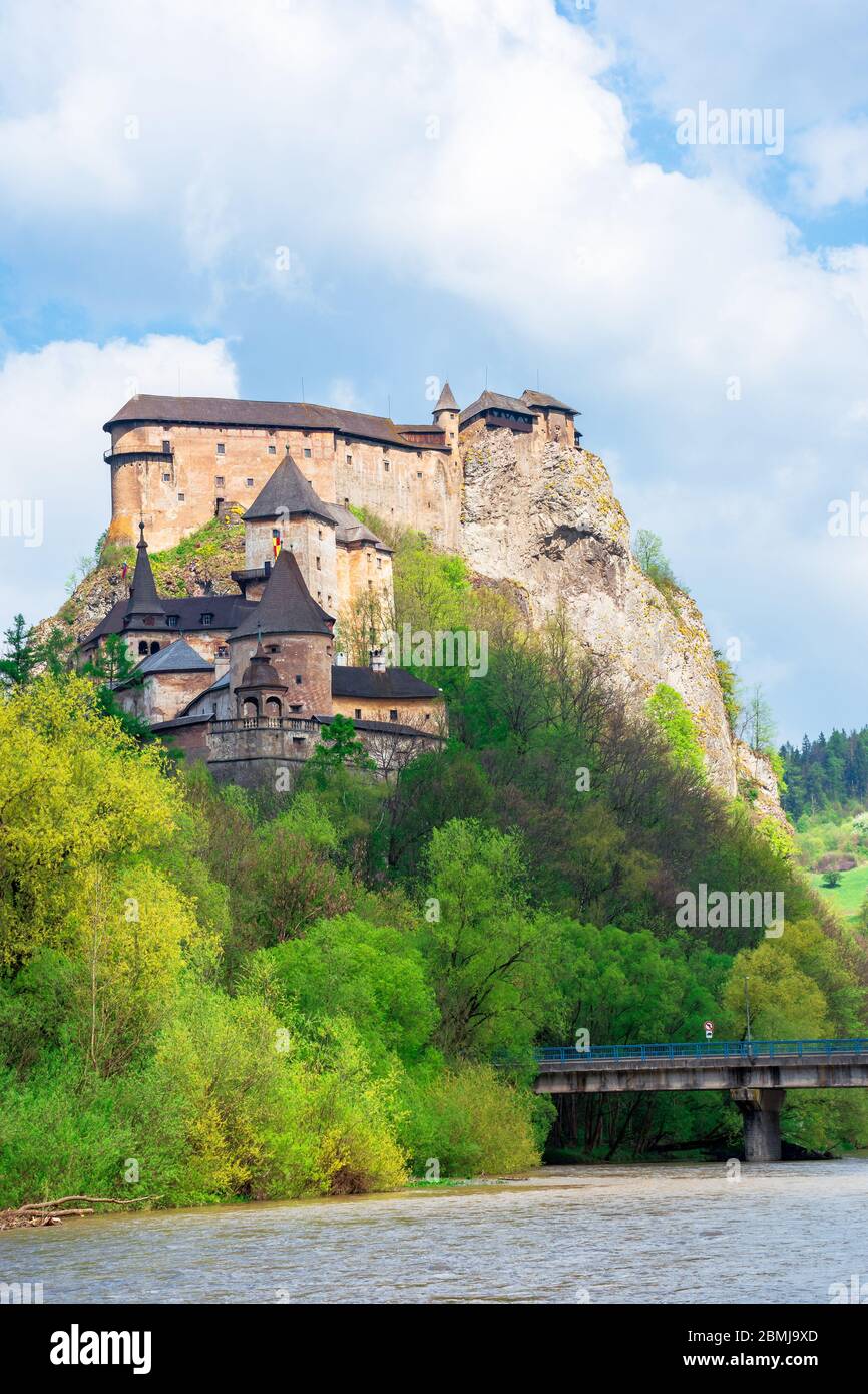 Mittelalterliche orava Burg auf dem Hügel. Schöne Frühlingslandschaft in gesprenkelten Licht über dem Fluss. Beliebtes Reiseziel der slowakei Stockfoto