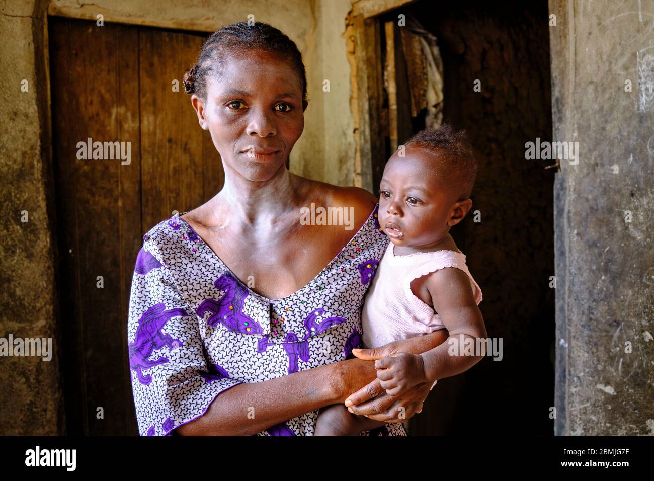 Edda Frau mit Schutzfarbe gegen böse Geister hält ihr Baby in den Armen. Stockfoto