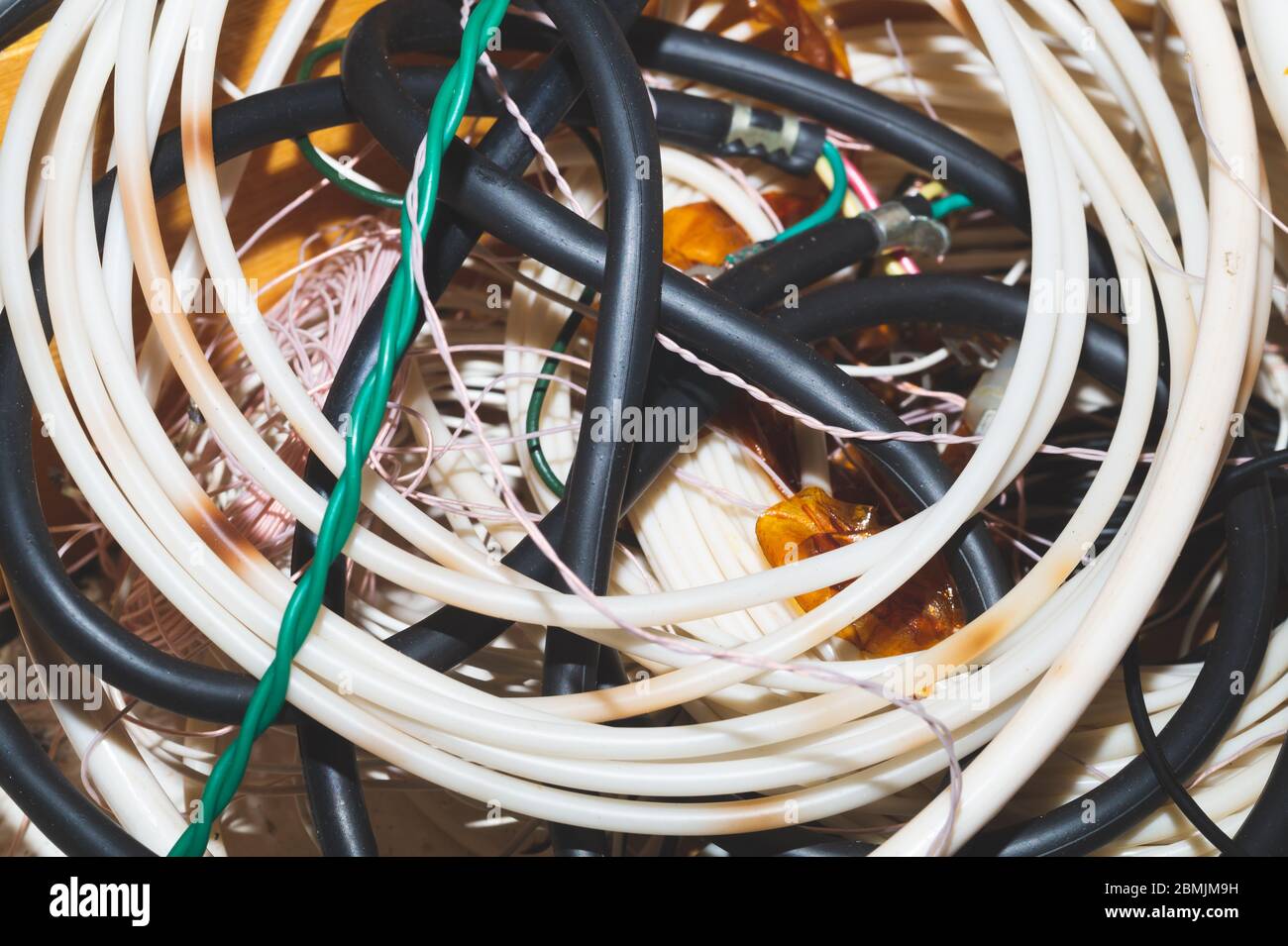 Alte Schläuche und Drähte Nahaufnahme. Verdrehte Schlauchleitung. Gartengeräte Stockfoto