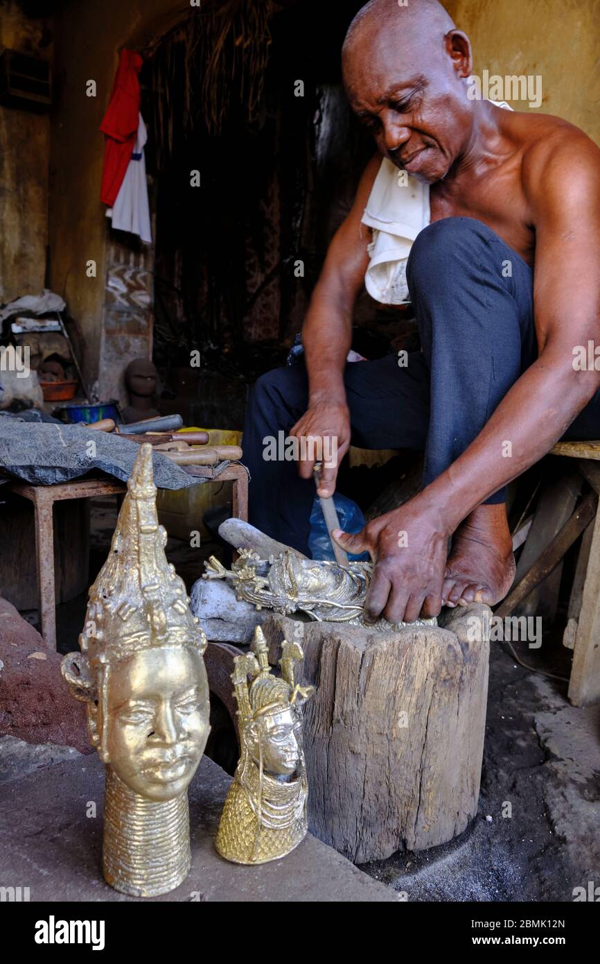 Handwerker, die die letzten Details einer Bronzestatuette polieren, die mit der Technik des Wachsausschmelzens hergestellt wurde, die im Königreich von Be verwendet wurde Stockfoto