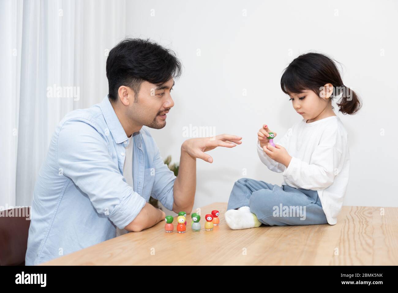 Ein Paar junger asiatischer Vater und Tochter tragen Nagellack im Wohnzimmer auf Stockfoto