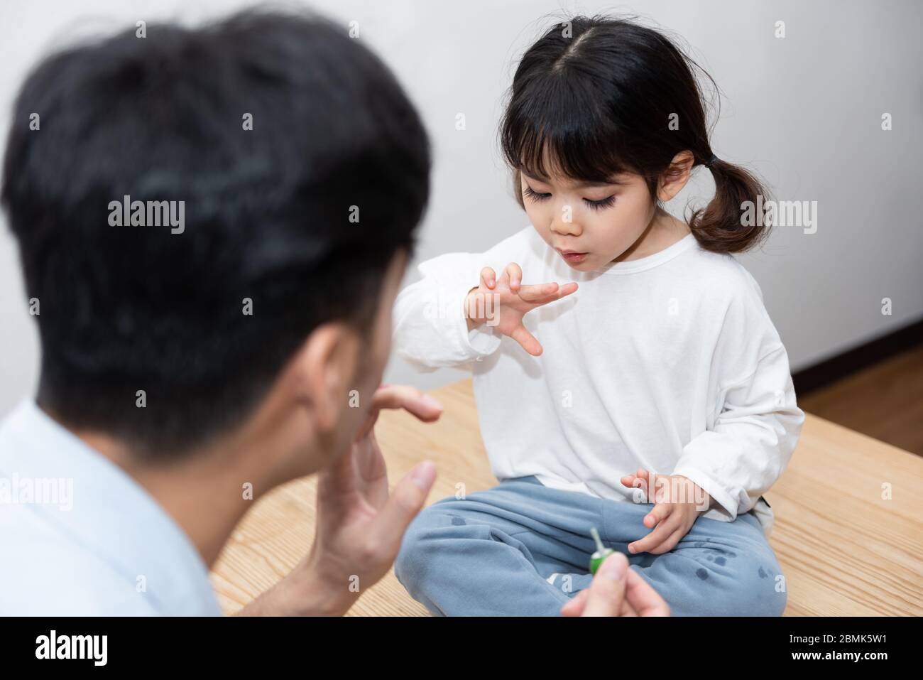 Ein Paar junger asiatischer Vater und Tochter tragen Nagellack im Wohnzimmer auf Stockfoto