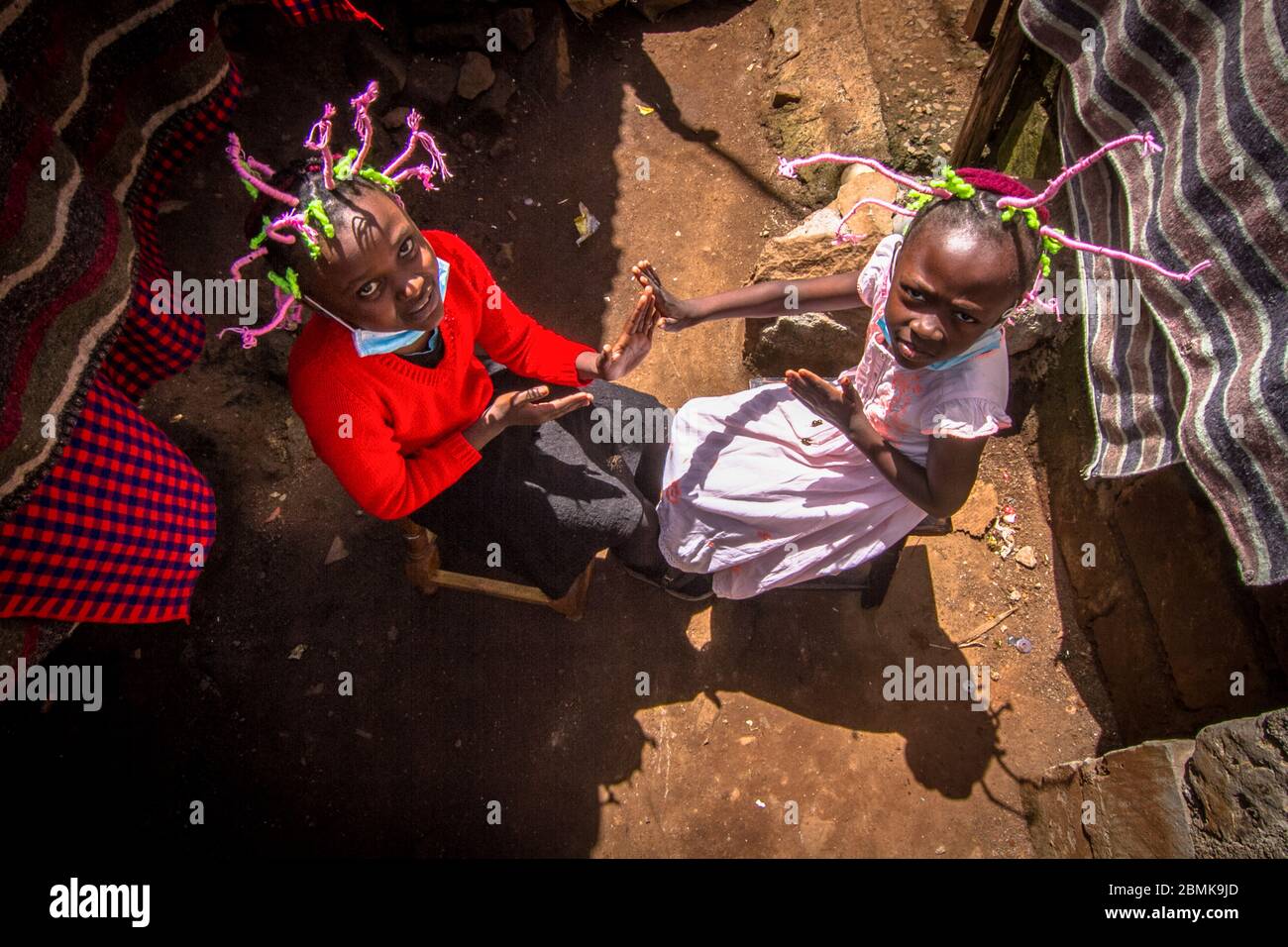 Nairobi, Kenia. Mai 2020. Die 12-jährige Martha Apisa (links) und ihre Nachbarin Stacy Ayuma (rechts) werden mit ihren Haarflechten beobachtet, um während der Pandemie Bewusstsein und Aufsehen über den Corona-Virus zu schaffen. Kenia hat 649 bestätigte Fälle, 207 wiedergewonnene und 30 Todesfälle durch die COVID 19-Krankheit verzeichnet. Quelle: SOPA Images Limited/Alamy Live News Stockfoto