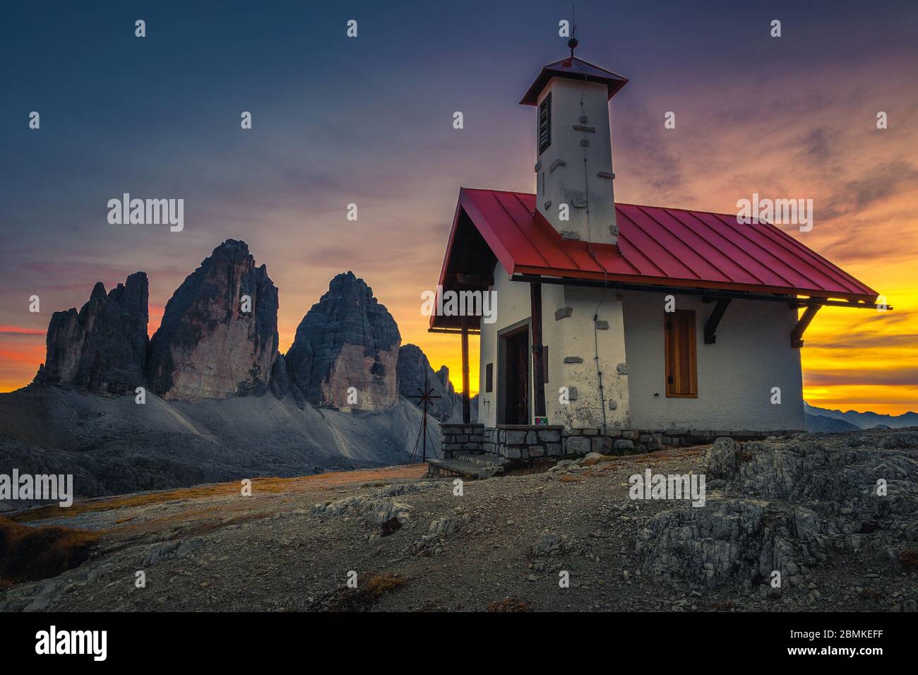 Nette kleine Kapelle und Tre Cime di Lavaredo Spitzen im Hintergrund bei Sonnenuntergang. Bekannte Wander- und Wallfahrtsort in den Dolomiten, Italien, Europa Stockfoto